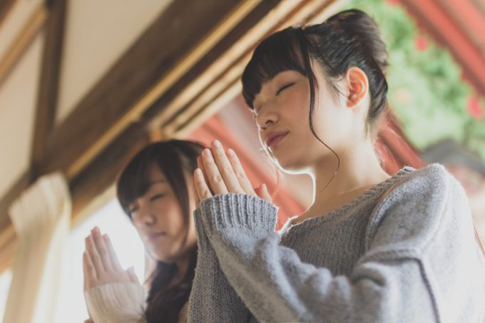 手を合わせてお祈りする2人の女性