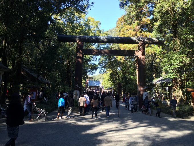 宮崎神宮の鳥居の前を通過する人達