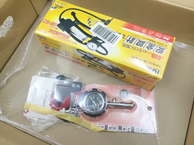 段ボールの中に入った、空気入れなどのバイク用品