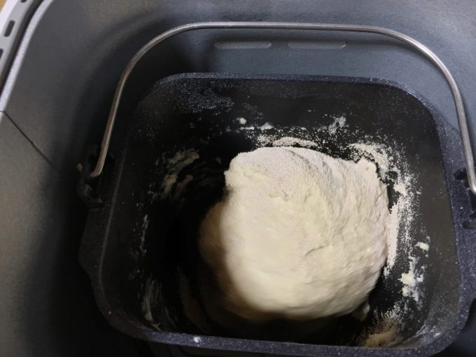 パンケースの中で混ぜられて練られてきたパン生地にドライイーストが投入された状態
