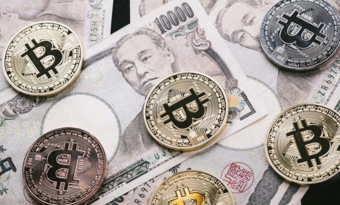 一万円札の上にのったビットコインを模した硬貨