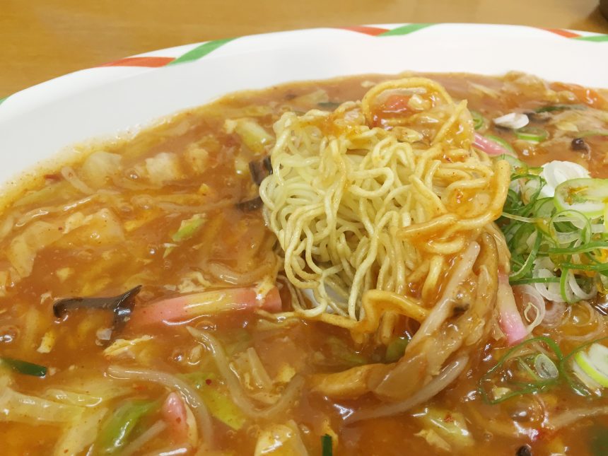 パリパリに焼かれたあんかけの麺を持ちあげた状態