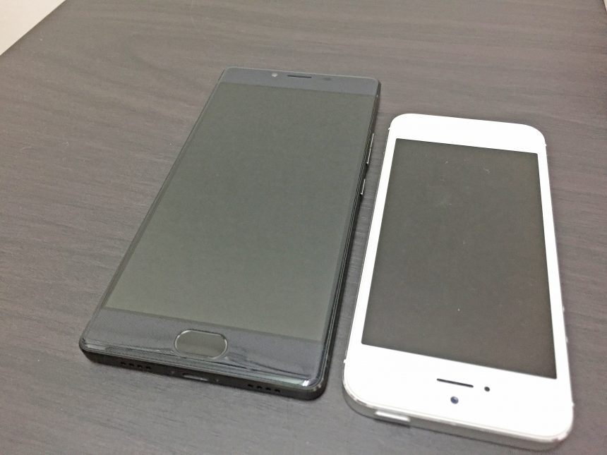 フリーテルREI（黒）とiPhone5（白）を机に並べて大きさを比較した状態